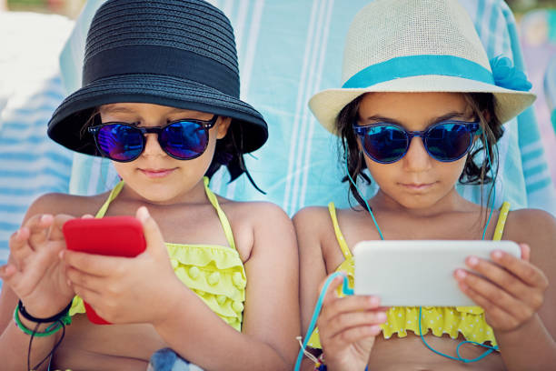 istock Girlfriends are using their mobile phones on the beach and sulking each other 1266428071