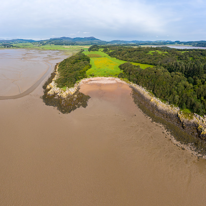 The view from a drone of a small sandy beach in south west Scotland. The image was captured in the morning on a Summers day at low tide. Several images were merged together to produce the panorama.