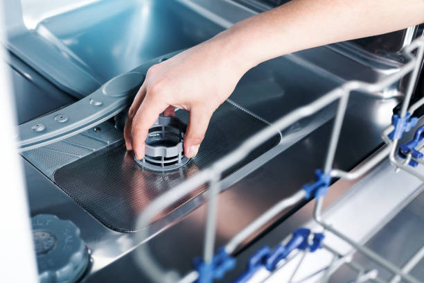 Part of dishwasher filter in male hand Part of dishwasher filter in male hand, cleaning service of home appliance dish washing machine inside, dishwasher stock pictures, royalty-free photos & images