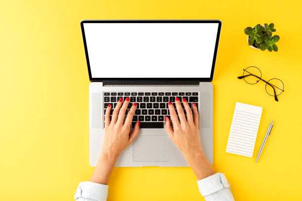 istock Female hands working on laptop with copyspace on yellow background with business accessories. Top view 1266433906
