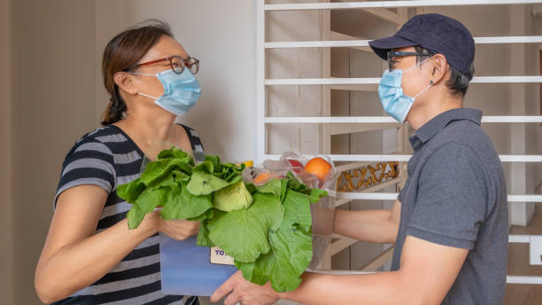 Courier wearing mask deliver groceries to customer