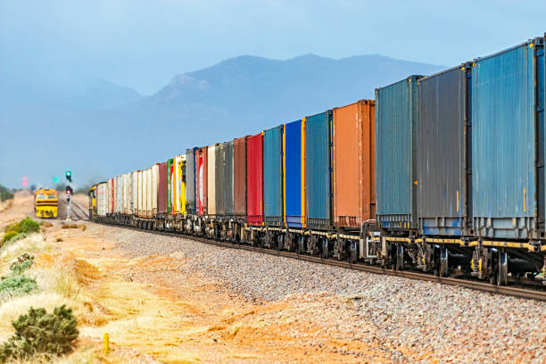 grünes licht für bunten container-güterzug in abgelegener lage mit bergen und nebel - land vehicle rail freight locomotive australia stock-fotos und bilder