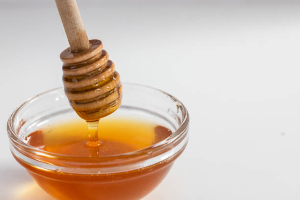 istock Honey dipper over glass ramekin 1266439833