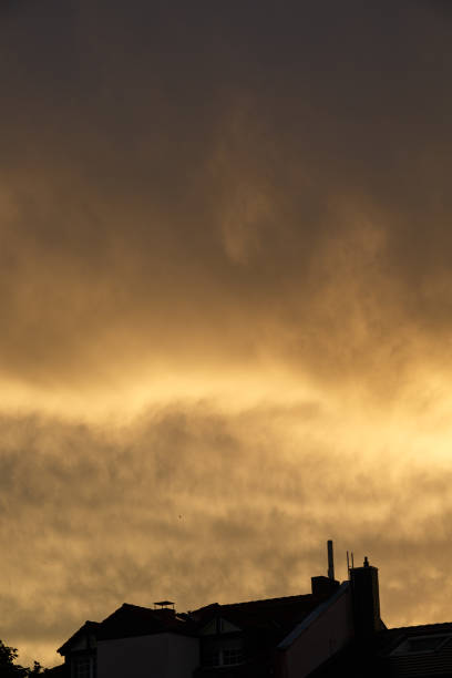 istock Sunset with dramatic sky and clouds over the roofs 1266442630