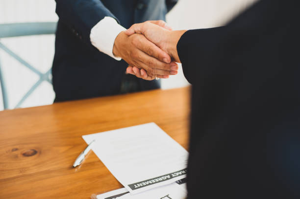 istock Businessman shakes hands with partners while signing contract. 1266442863