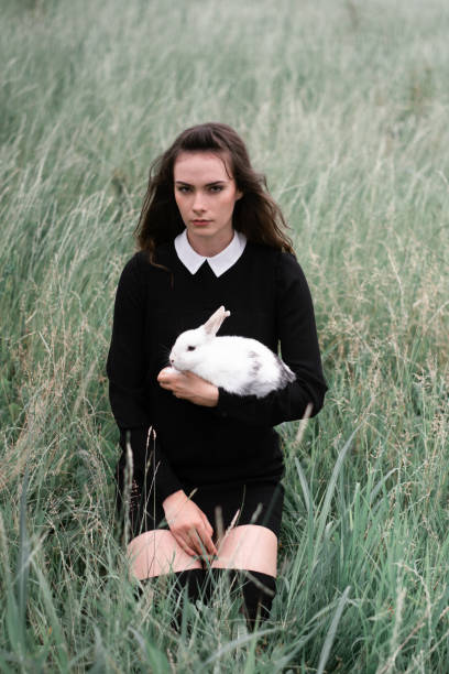 istock Beautiful girl posing in nature holding white rabbit 1266442971