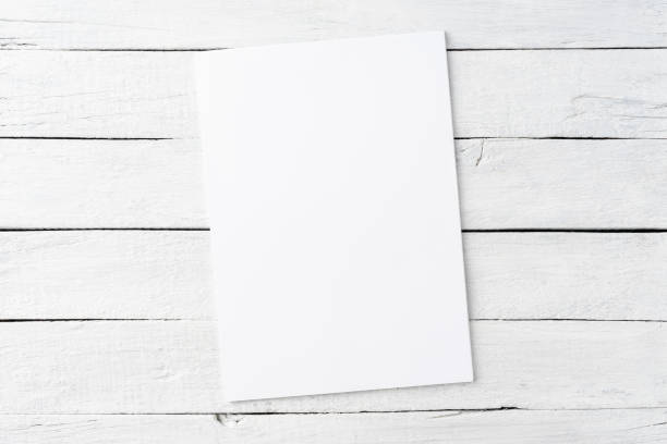 istock Blank white sheet of paper on rustic wooden background. Top view 1266446322