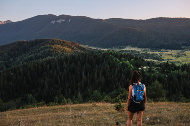 Backpacker woman spending the weekend in the nature, hiking in the mountains.