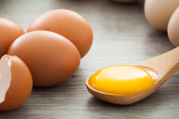 istock Raw egg yolk on wooden table 1266451174