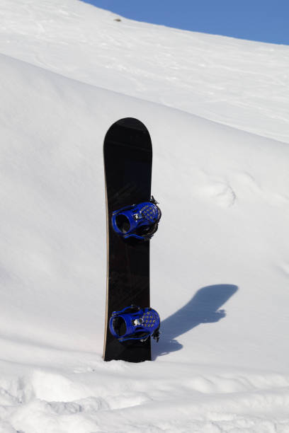 istock Snowboard in snowdrift after snowfall and snowy slope for freeride in background 1266453048