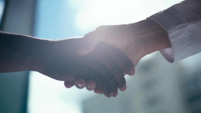 Close-up handshaking of two colleagues African business man and Caucasian businessman .