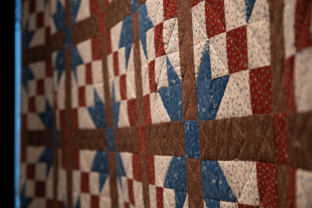 Old-fashioned quilt Red, white, brown, and blue patchwork quilt on display. The fabrics used all have tiny flowers on them. patriotic quilt stock pictures, royalty-free photos & images