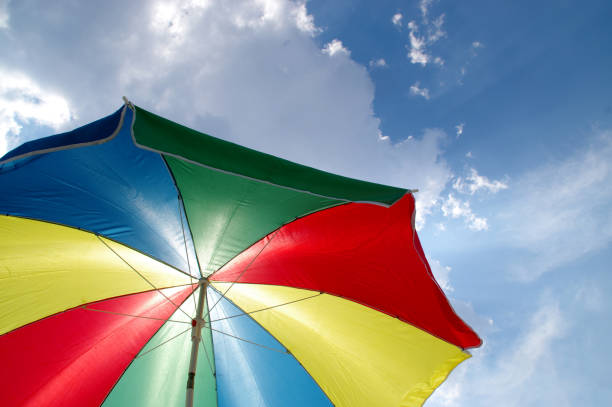 istock Beach sun parasol on the background of clouds and sky 1266454936