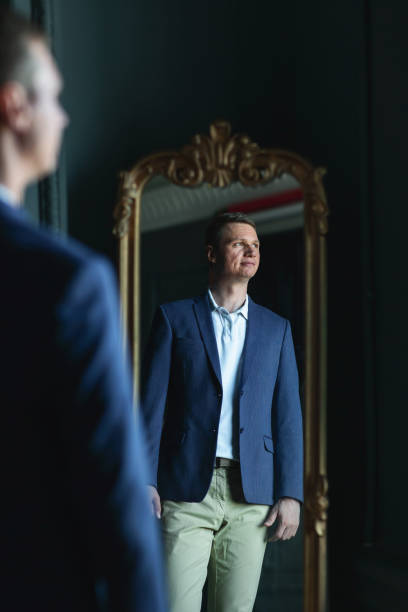istock Handsome stylish man in blue jacket at home looking aside 1266455403