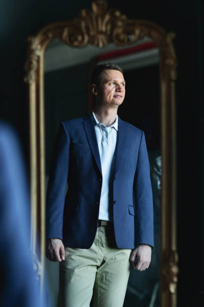 istock Handsome stylish man in blue jacket at home looking aside 1266455405