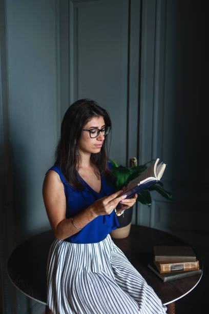 istock Woman in elegant clothes sitting on table in modern interior 1266455447