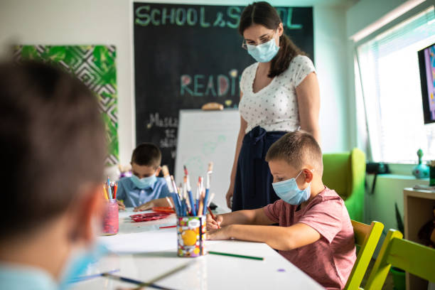 istock Schoolboys and teacher during art class at classroom 1266458589