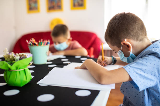 istock Schoolboys with protective face masks on class during covid-19 pandemic 1266458696