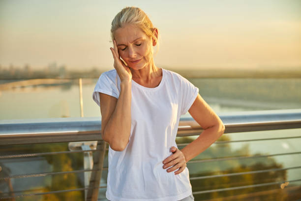 istock Unhappy woman having headache while standing on the street 1266458849
