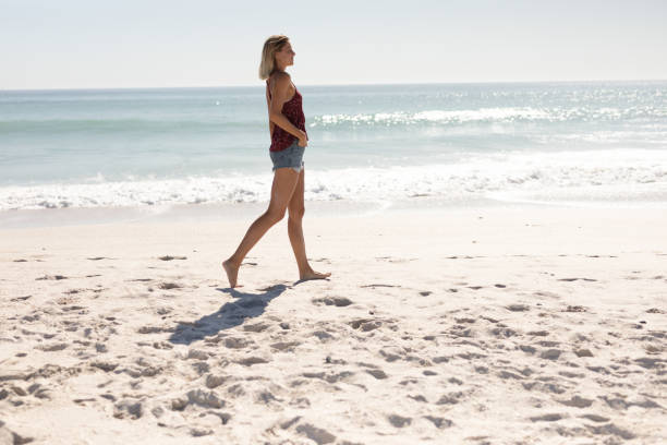 istock Young Caucasian woman walking on the beach 1266460832