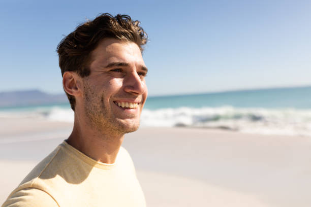 istock Young caucasian man smiling on the beach 1266461290