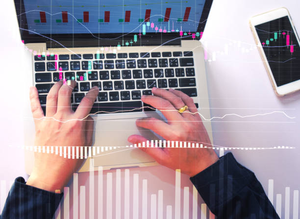 istock top view stock trader hand using laptop for analyzing stock market graph, stock exchange graph analysis concept 1266462071