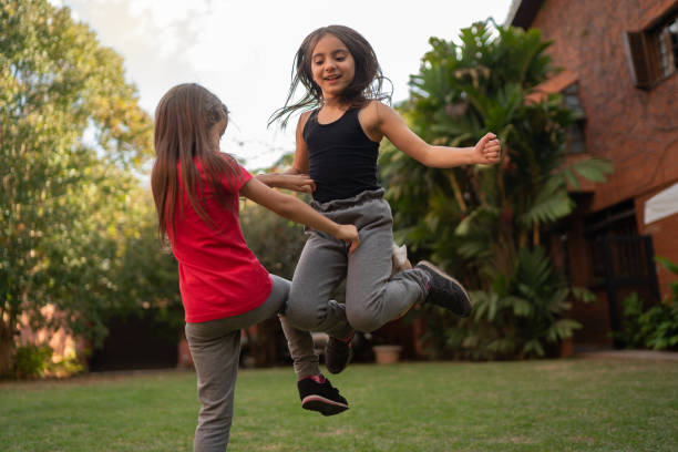 istock Girls jumping and dancing in the backyard 1266463493