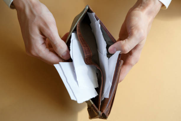 istock Empty wallet with paper in the hands of a man on a plain background 1266463534