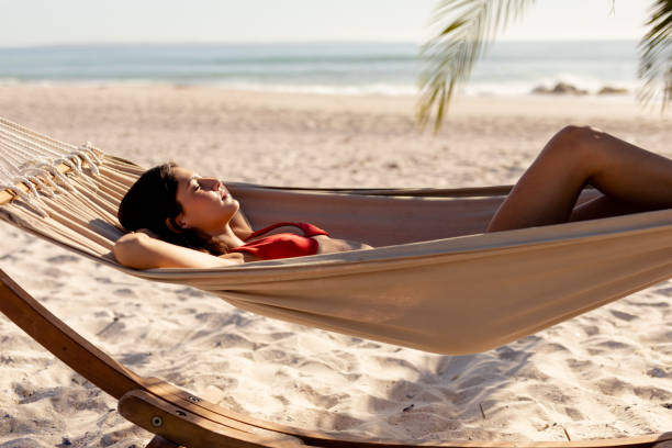 istock Young caucasian woman laying on hammock on beach 1266463556