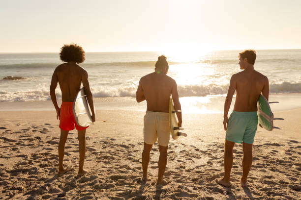 istock Young mixed race men holding surf boards on beach 1266464710