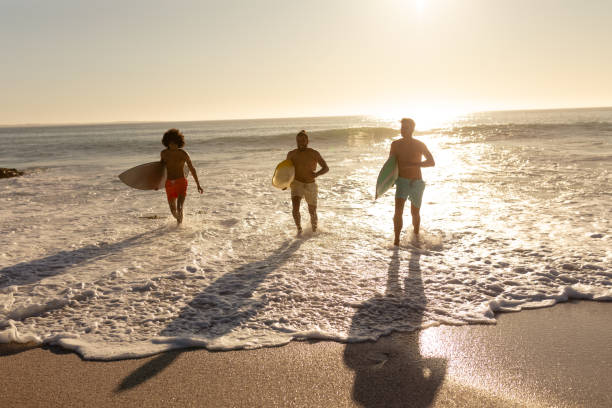 istock Young mixed race men holding surf boards on beach 1266464717