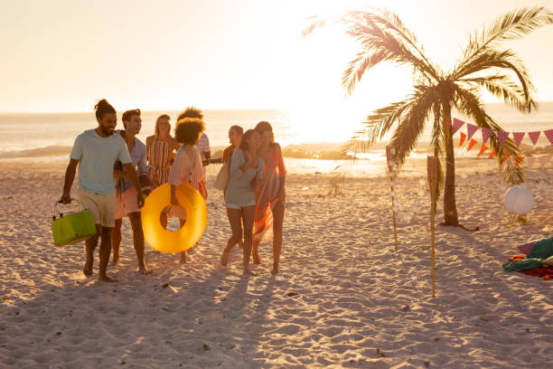 istock Mixed race friends group walking on beach 1266465591