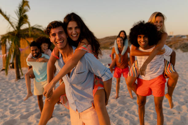 istock Mixed race friends having fun on beach 1266466728
