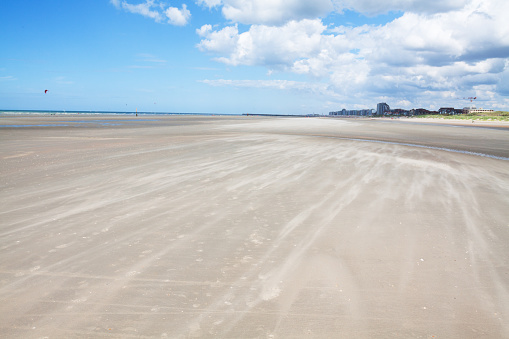 Wind over sand and beach of Nieuport in Belgium. In background is city. Beach between DePanne and Nieuport in Belgium