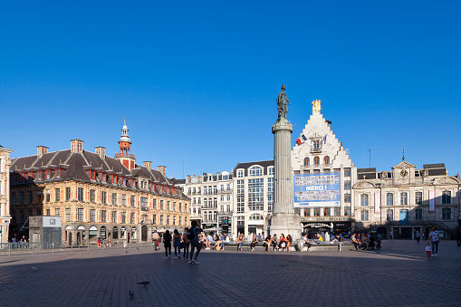 Lille, France - June 22 2020: The Grand Place with the Old Stock Exchange (Vieille Bourse), the Column of the Goddess (Colonne de la Déesse), the building of the newspaper La Voix du Nord and the North theater (Théâtre du Nord).
