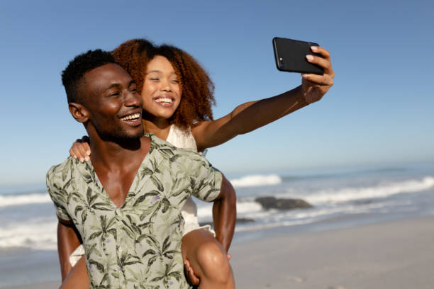 istock Happy couple taking a selfie on the beach 1266467782