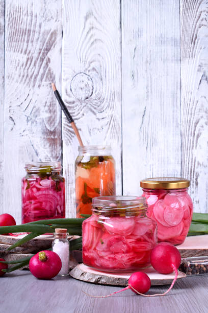 Chopped radish, carrot and red onion marinated in glass jars
