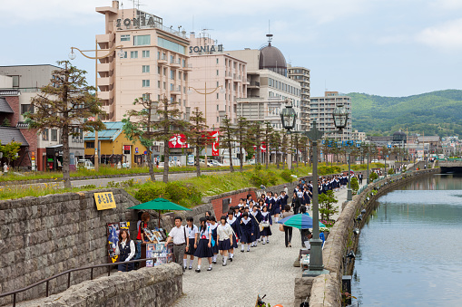 Students visiting Otaru Canal in Oraru, Hokkaido, Japan. Many warehouses are on the canal. Otaru Canal is the symbol in Hokkaido. In Meiji Period, Otaru was the significant port in Hokkaido. Nowadays, the canal became a tourist attraction.