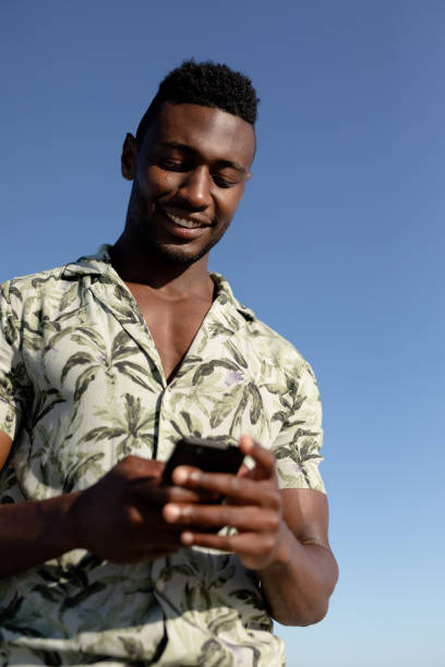 istock African american man using his phone on the beach 1266468931