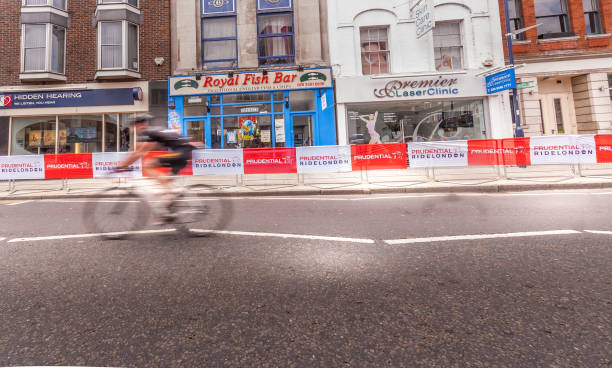 The Rider A solitary bike rider on Putney High Street in London putney photos stock pictures, royalty-free photos & images