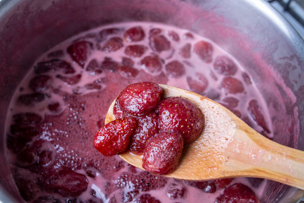 istock Cooking strawberry jam in a silver pot on the stove 1266482059