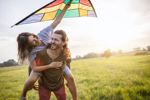 istock Happy couple running a kite 1266482160