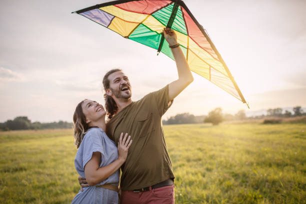 istock Happy couple running a kite 1266482237