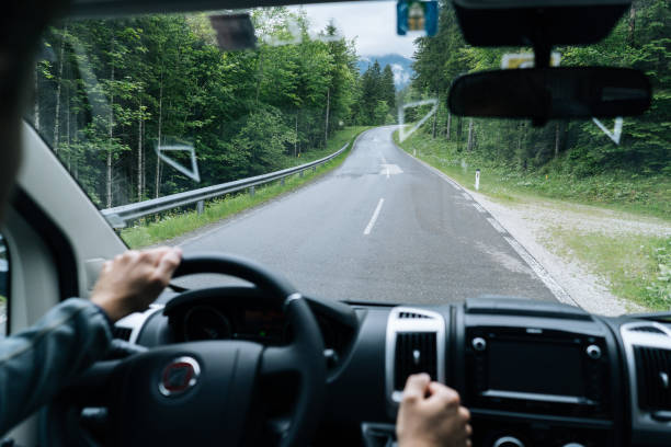 istock POV past hands driving a motor home down a two lane road 1266484003