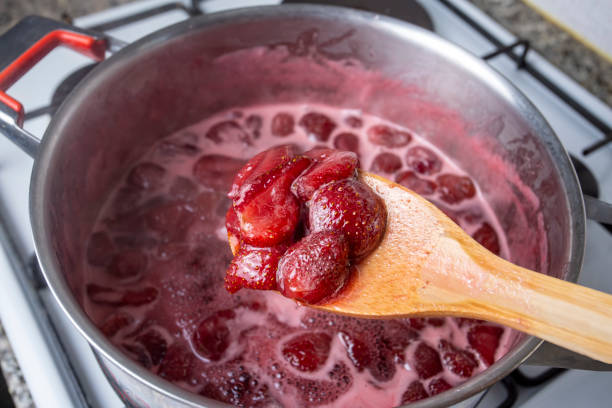 istock Cooking strawberry jam in a silver pot on the stove 1266486077