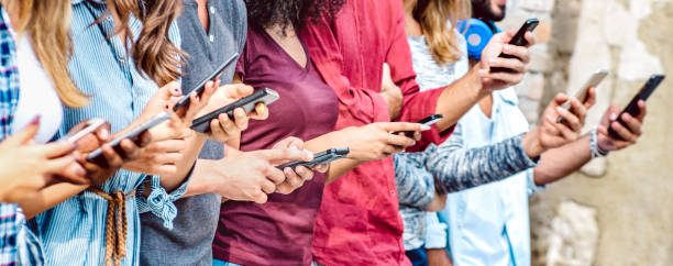 vue recadrée sur les mains millénaires à l’aide de téléphones intelligents mobiles - personnes accros par les smartphones - concept technologique avec des adolescents toujours connectés - profondeur de champ peu profonde avec l’accent sur l’app - digital native photos et images de collection