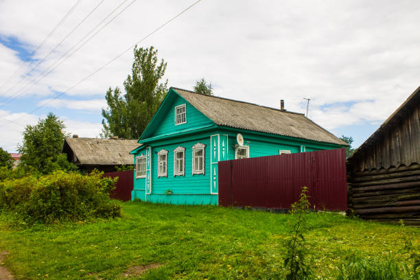 a street with old wooden Russian huts and green trees on a summer day and space for copying in Kalyazin Tver region