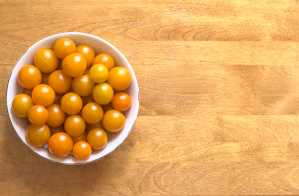 Yellow cherry tomatoes in a porcelain bowl stock photo