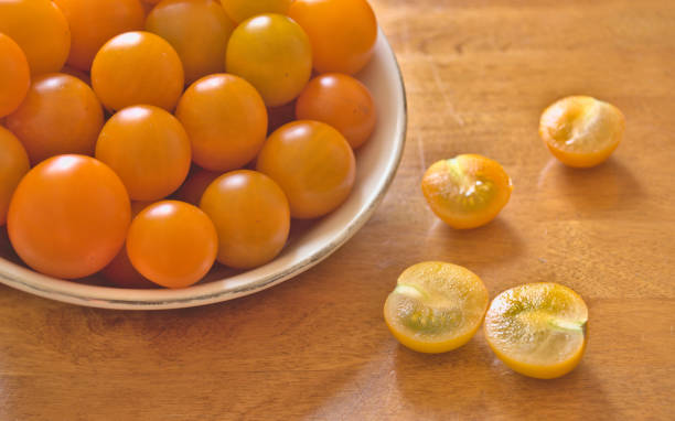 Yellow cherry tomatoes in a porcelain bowl stock photo