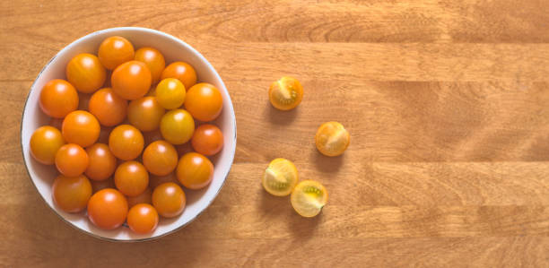 Yellow cherry tomatoes in a porcelain bowl stock photo